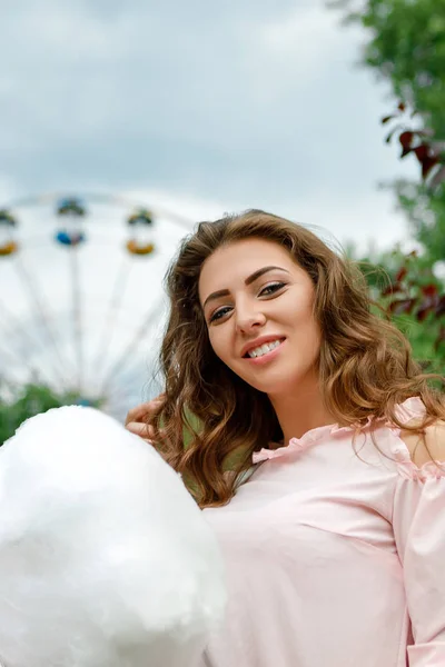 Attractive woman holding sweet cotton candy — Stock Photo, Image