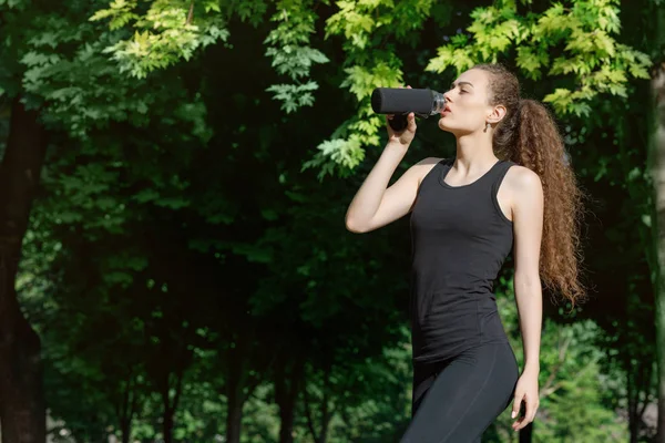 Женщина пьет воду после бега — стоковое фото