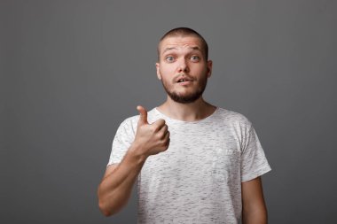 Genç adam bir başparmak yukarıya jest gösterilen