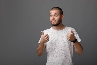 Genç adam bir başparmak yukarıya jest gösterilen