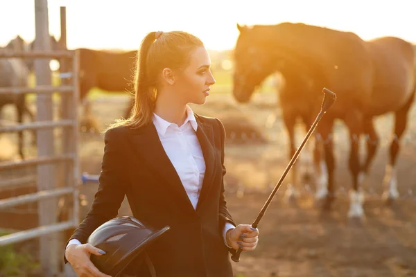 Rider woman with whip at the sunset — Stock Photo, Image