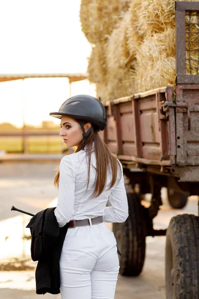 Rider woman in helmet stands near stables — Stock Photo, Image