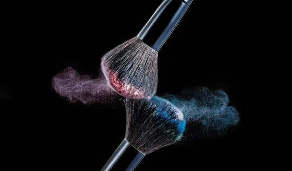 Maquiagem escova com salpicos de pó no fundo preto — Fotografia de Stock