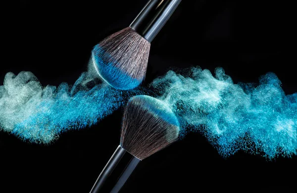 Maquillaje cepillo con salpicaduras de polvo sobre fondo negro — Foto de Stock