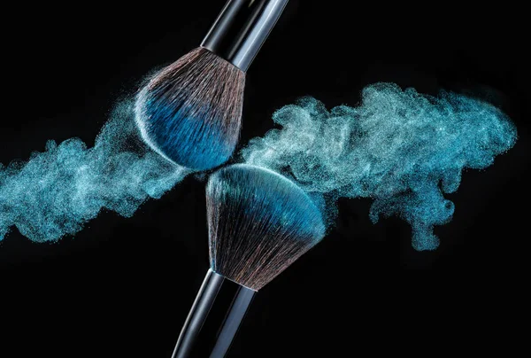 Make up brush with powder splashes on black background — Stock Photo, Image