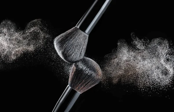 Brosse de maquillage avec éclaboussures de poudre sur fond noir — Photo