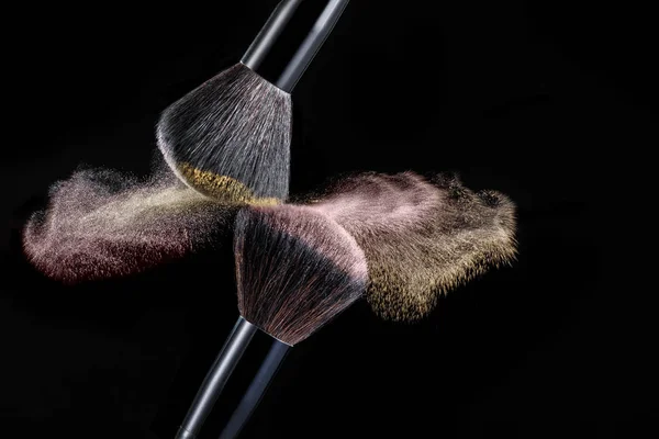 Make up brush with powder splashes on black background — Stock Photo, Image