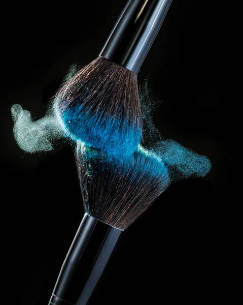 Make up brush with powder splashes on black background — Stock Photo, Image