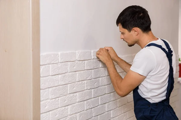 Профессиональный строитель приклеивает декоративную плитку к стене . — стоковое фото