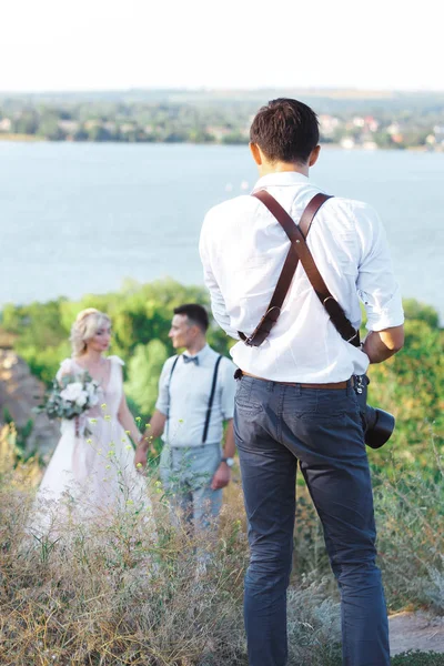 wedding photographer takes pictures of bride and groom