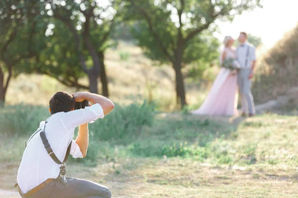 Düğün fotoğrafçısı gelin ve damadın fotoğraflarını çeker. — Stok fotoğraf