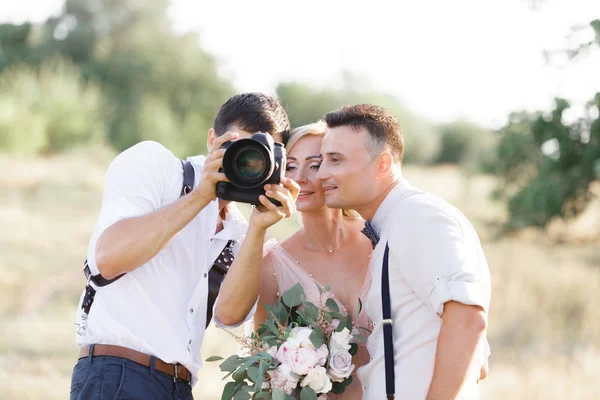 Svatební fotograf fotí nevěstu a ženicha — Stock fotografie