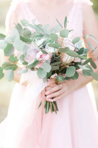 Le mani delle spose tengono un bellissimo bouquet da sposa all'aperto — Foto Stock