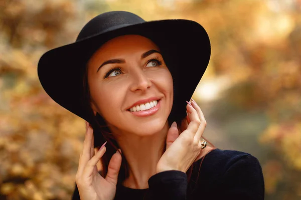 Vrouw in jurk en hoed op de achtergrond van de herfst bladeren — Stockfoto
