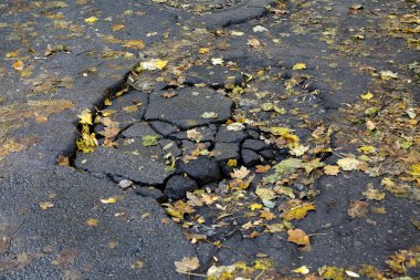 Asfalt yolda taşlarla büyük çukur