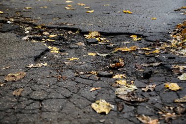 Asfalt yolda taşlarla büyük çukur