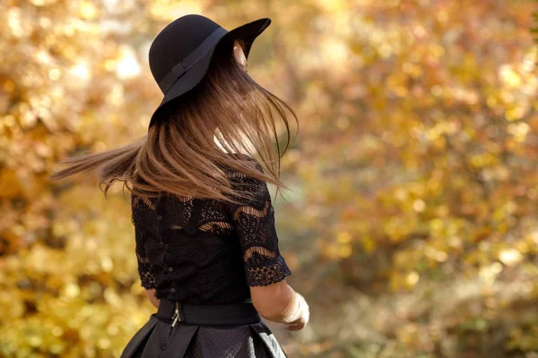 美丽的女人在黑色礼服和帽子在秋天 — 图库照片