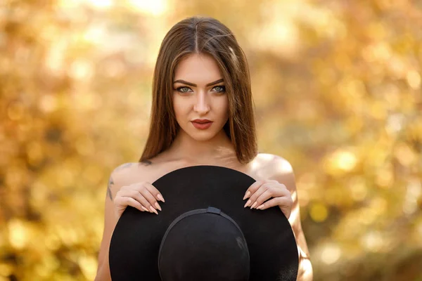 Bella donna in abito nero e cappello in autunno — Foto Stock
