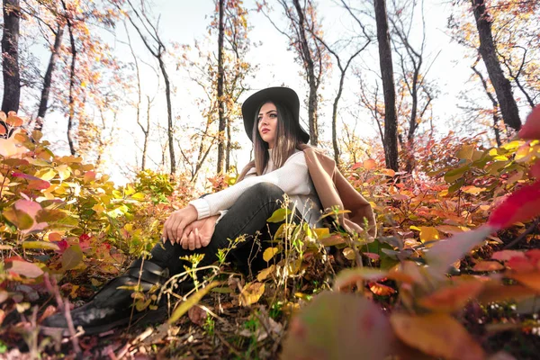 Красивая счастливая женщина в пальто и шляпе в лесу — стоковое фото