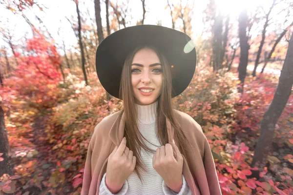 Mujer en sombrero negro sobre fondo de hojas de otoño . — Foto de Stock