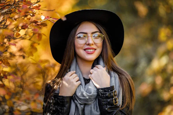 Hermosa mujer en vestido negro y sombrero en otoño — Foto de Stock