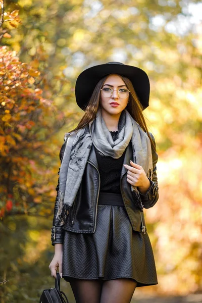 Schöne Frau in schwarzem Kleid und Hut im Herbst — Stockfoto