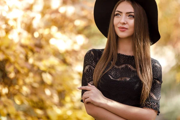 Bela mulher em vestido preto e chapéu no outono — Fotografia de Stock