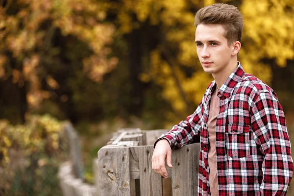 Handsome young guy in nature on an autumn day — Stock Photo, Image