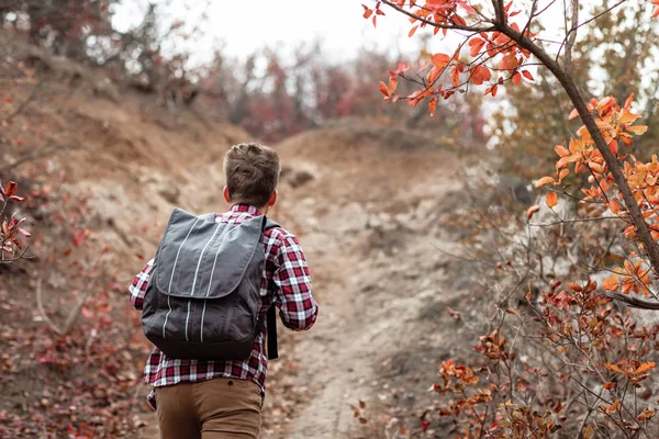 Young man tourist with backpack walking on nature. — Stock Photo, Image