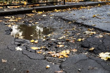 Asfalt yolda taşlarla büyük çukur