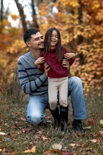 Baba küçük kızı kızla sarı yapraklar arka plan üzerinde yürür. — Stok fotoğraf