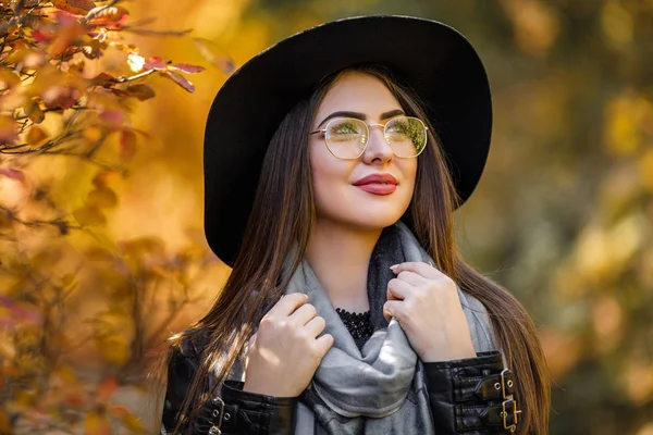 Hermosa mujer en vestido negro y sombrero en otoño — Foto de Stock