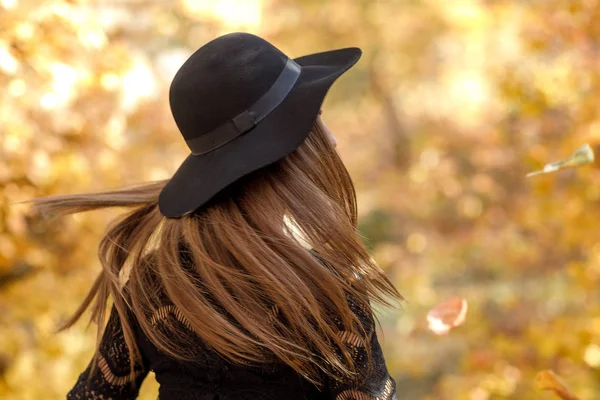 Vacker kvinna i svart klänning och hatt i höst — Stockfoto