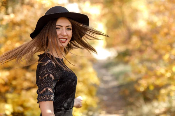 Belle femme en robe noire et chapeau en automne — Photo