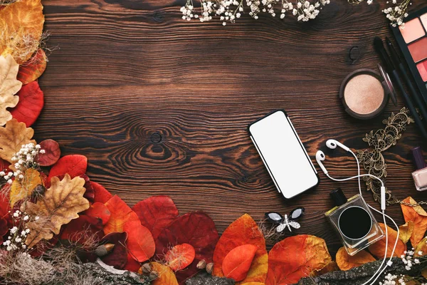 Accesorios femeninos Set. hojas de otoño, smartphone y auriculares sobre fondo de madera — Foto de Stock