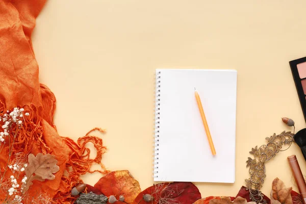 Осенние листья, шарф, бумажный блокнот и ноутбук на желтом фоне — стоковое фото