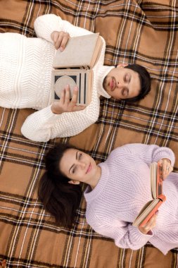 Sonbahar parkta oturan ve kitap okuma aşık çift