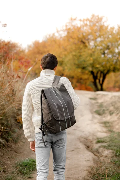 Young man tourist with backpack walking up the trail path — Stock Photo, Image