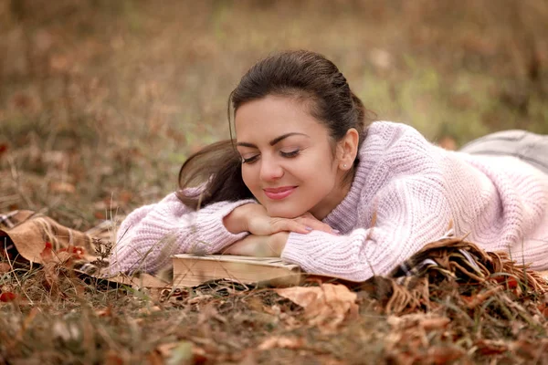 Sonbahar parkta oturan ve kitap okuma kadın — Stok fotoğraf