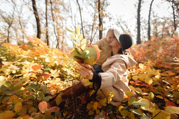 Mutter und kleine Tochter amüsieren sich im Herbst — Stockfoto
