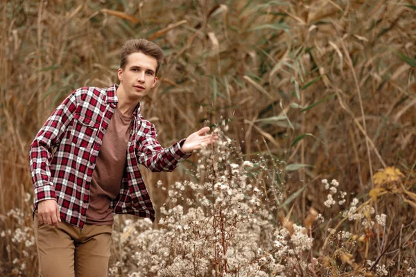 Guapo joven en la naturaleza en un día de otoño — Foto de Stock