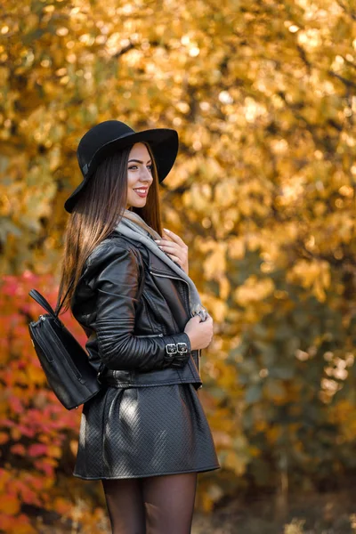 Красивая женщина в черном платье и шляпе осенью — стоковое фото