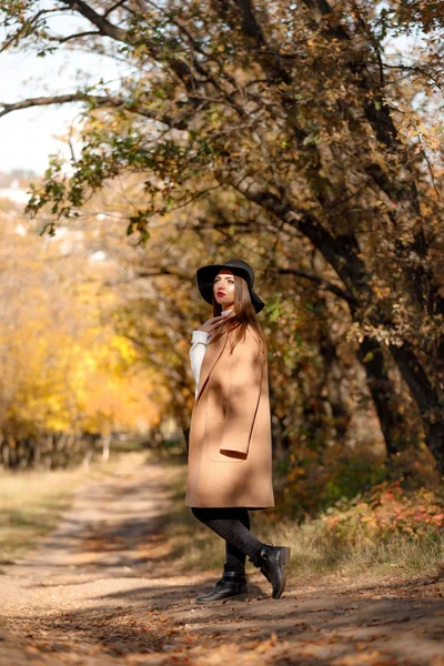 Hermosa joven con abrigo y sombrero negro — Foto de Stock