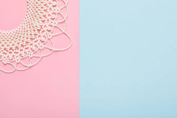 Perlenkette auf blauem und rosa Hintergrund — Stockfoto
