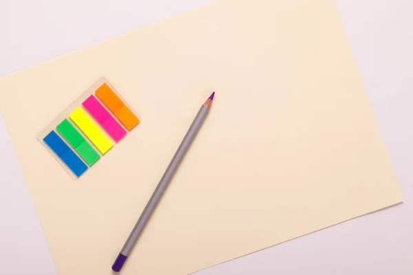 Lápis multicoloridos em papel multicolorido, vista superior — Fotografia de Stock