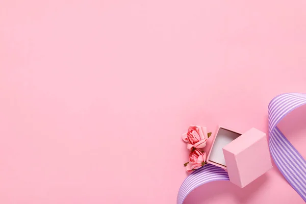 Ροζ συσκευασία δώρου και λουλούδια σε ροζ φόντο — Φωτογραφία Αρχείου
