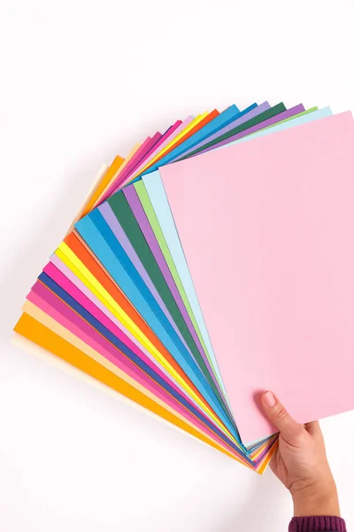 Ženská ruka drží listy různých barevného papíru. — Stock fotografie