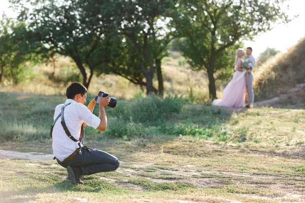 Düğün fotoğrafçısı gelin ve damadın fotoğraflarını çeker. — Stok fotoğraf