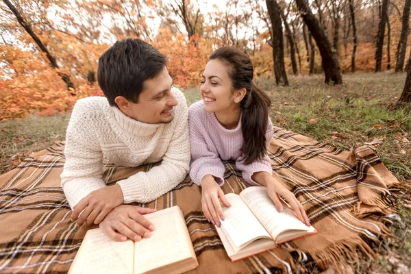 情侣在爱坐在秋天的公园和阅读书籍 — 图库照片