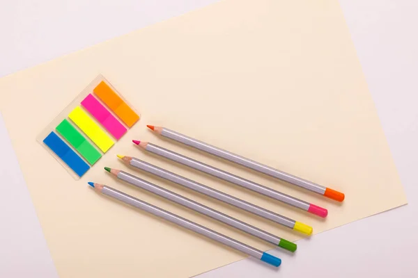 Lápis multicoloridos em papel multicolorido, vista superior — Fotografia de Stock